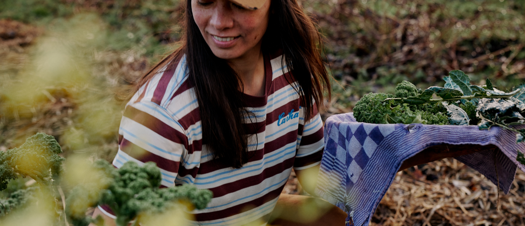 en kvinna som plockar blad i trädgården