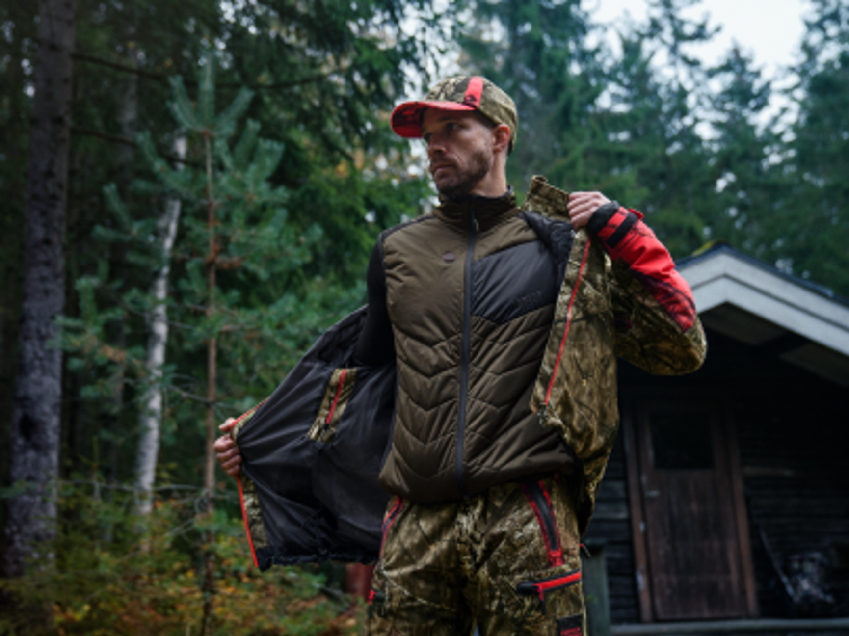jägare som tar på sig en jaktjacka