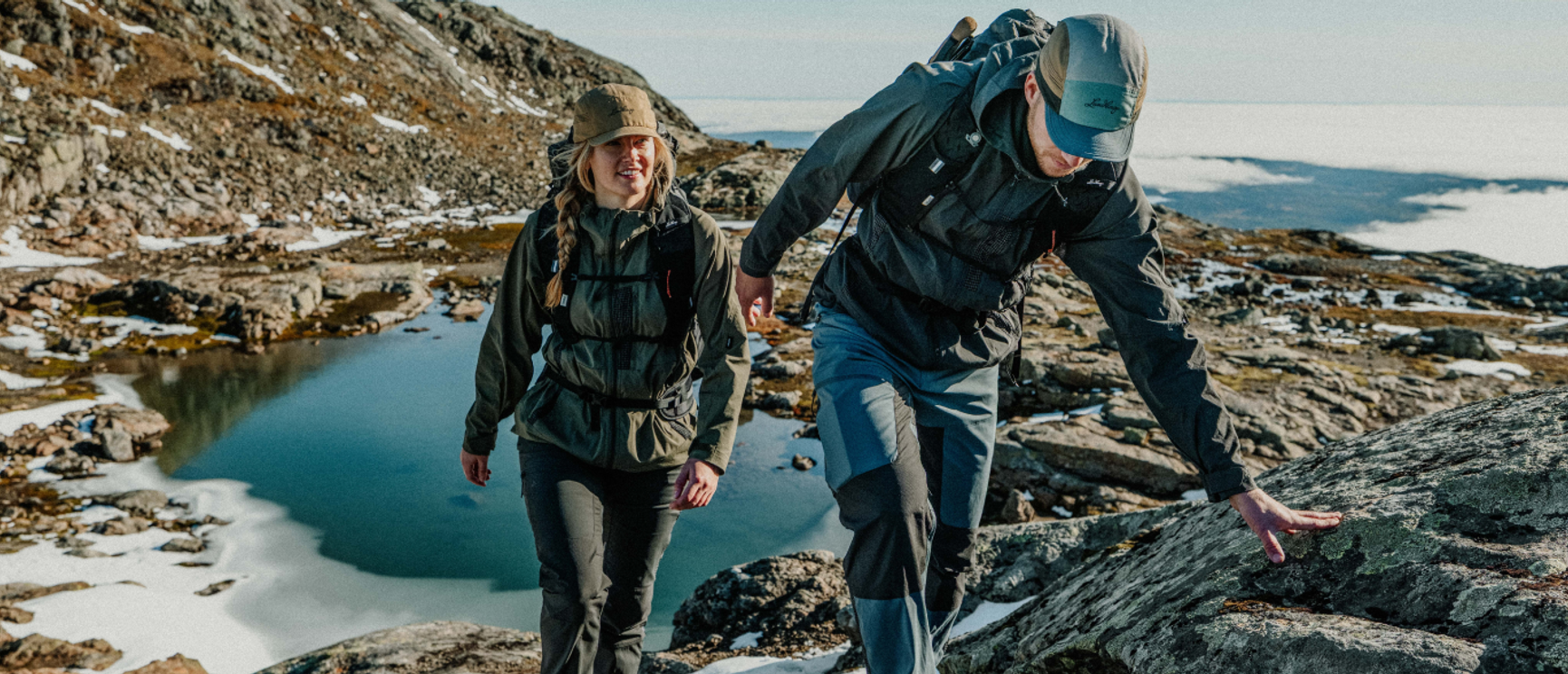 två personer som vandrar i fjällen på sommaren