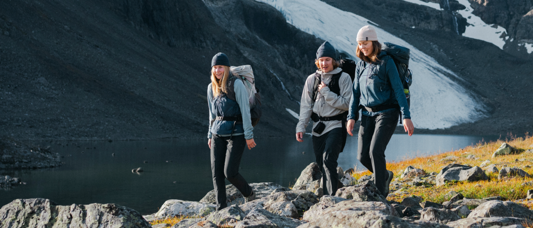 tre personer som vandrar på fjället en solig dag