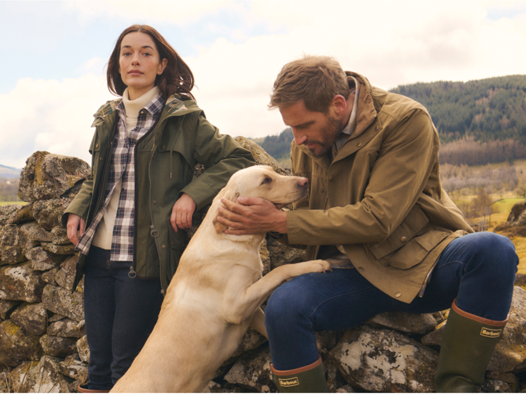 två personer och en hund på en hed