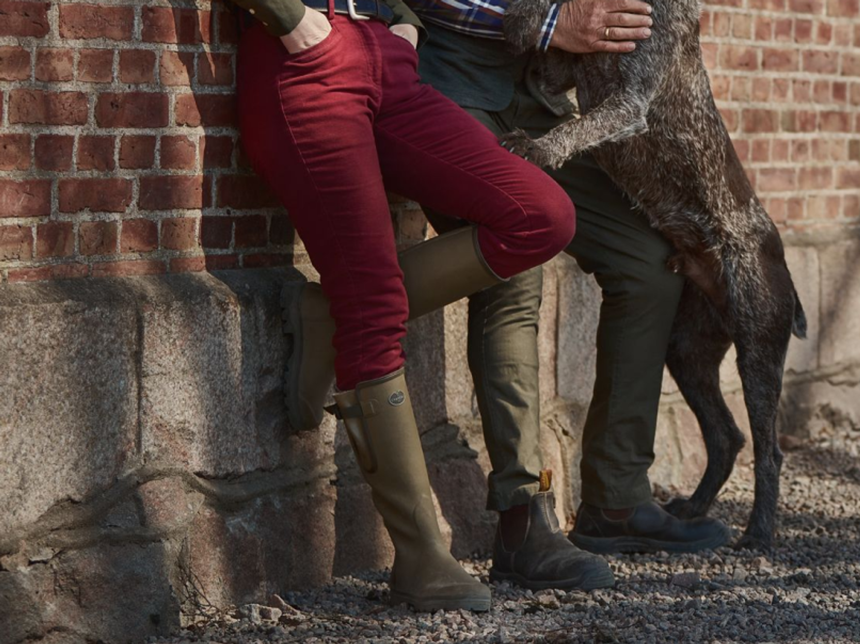 två personer som lutar sig mot en tegelvägg