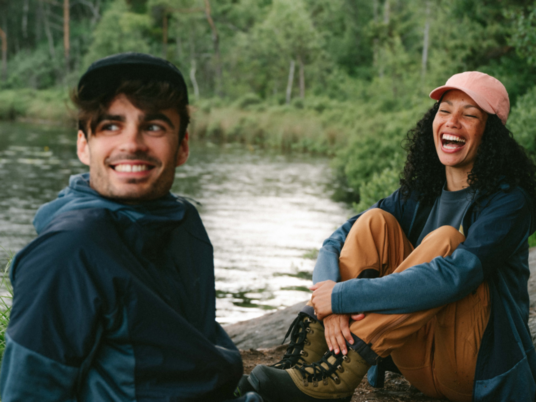 två personer i vandringskläder vid en å