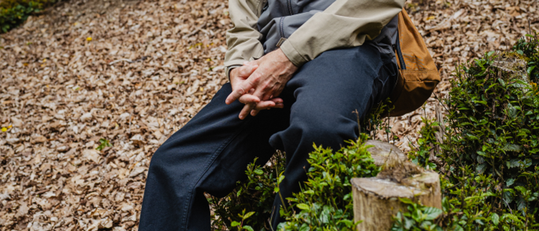 person som sitter på en stubbe
