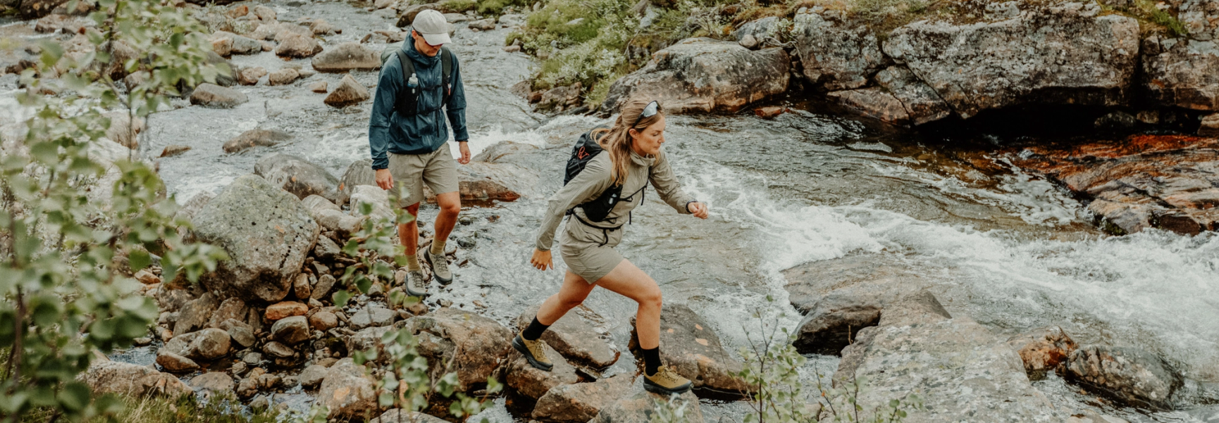 två fjällvandrare som går vid en fors