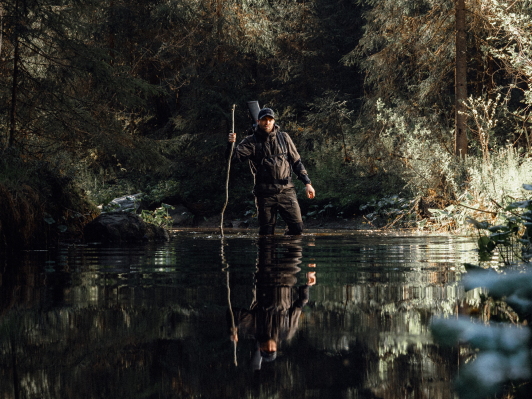 jägare som vadar över ett vattendrag