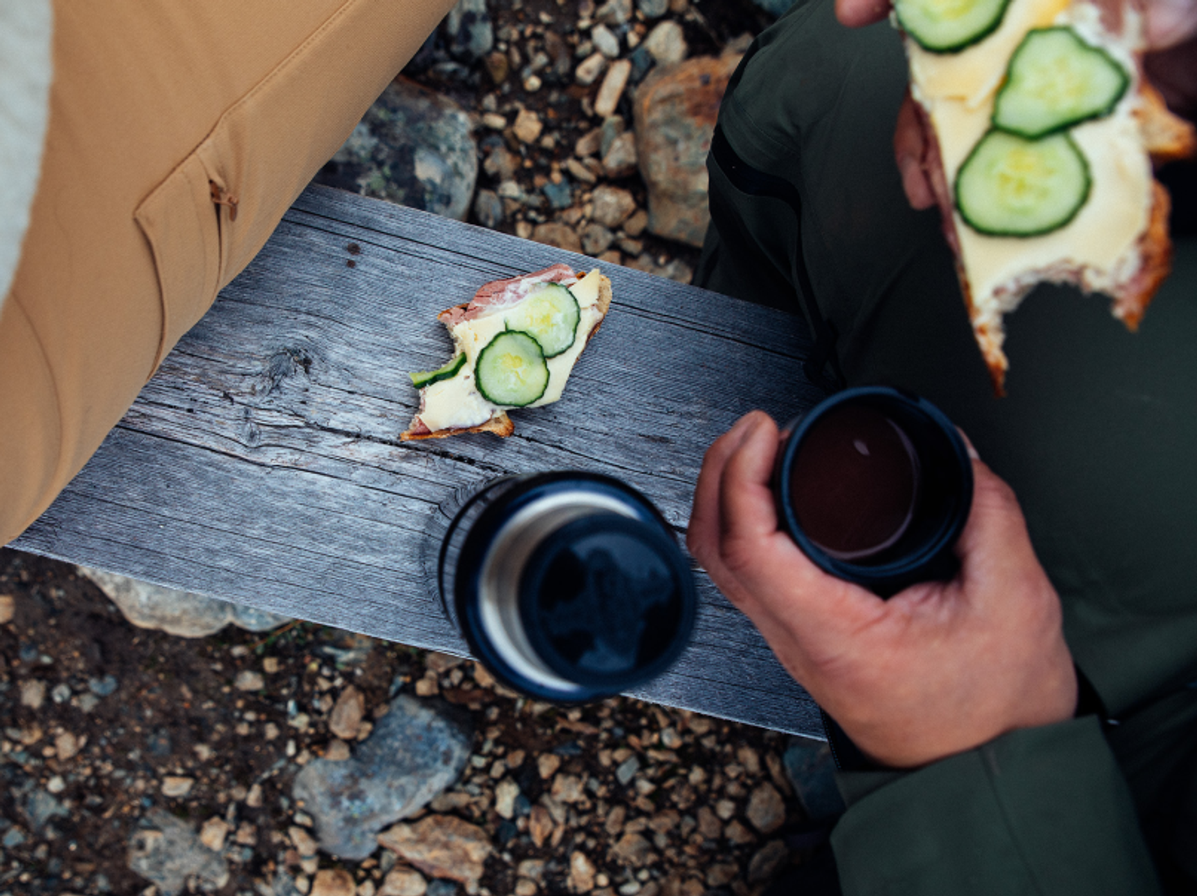ostmacka och termos på en bänk i naturen