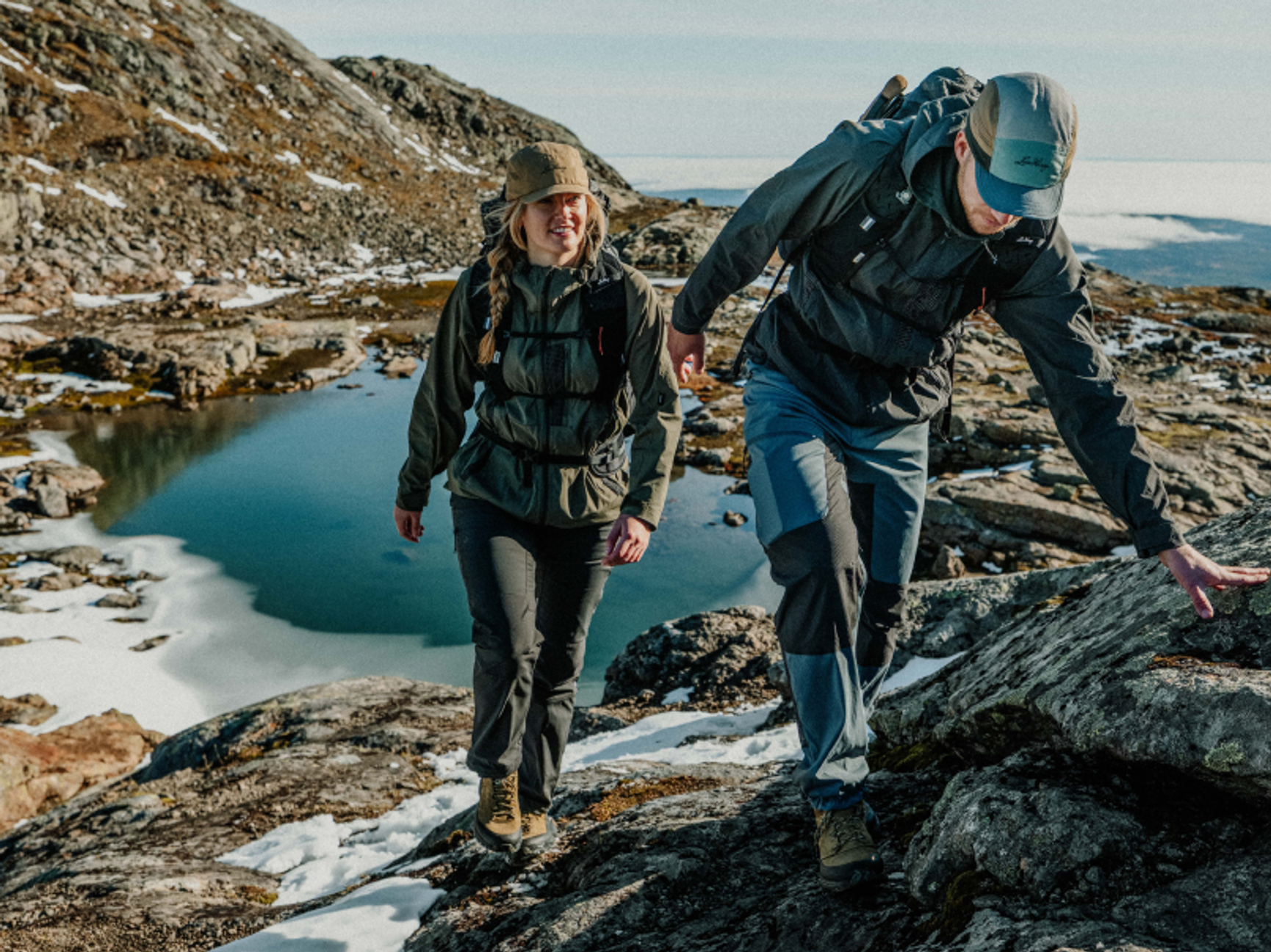två personer som vandrar i fjällen på sommaren