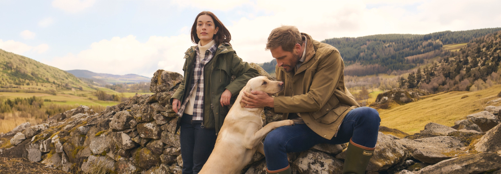 två personer och en hund på en hed