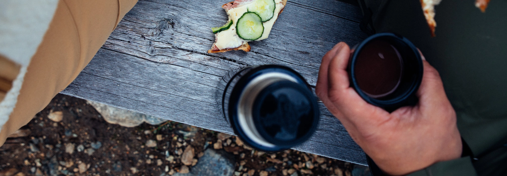 ostmacka och termos på en bänk i naturen