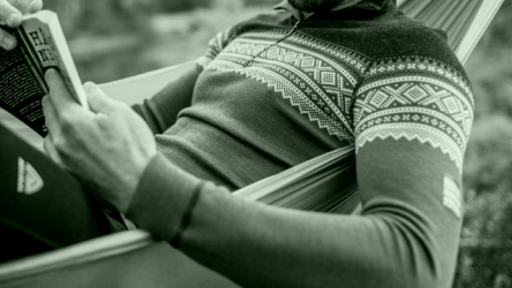 mann i hengekøye som leser i ullgenser