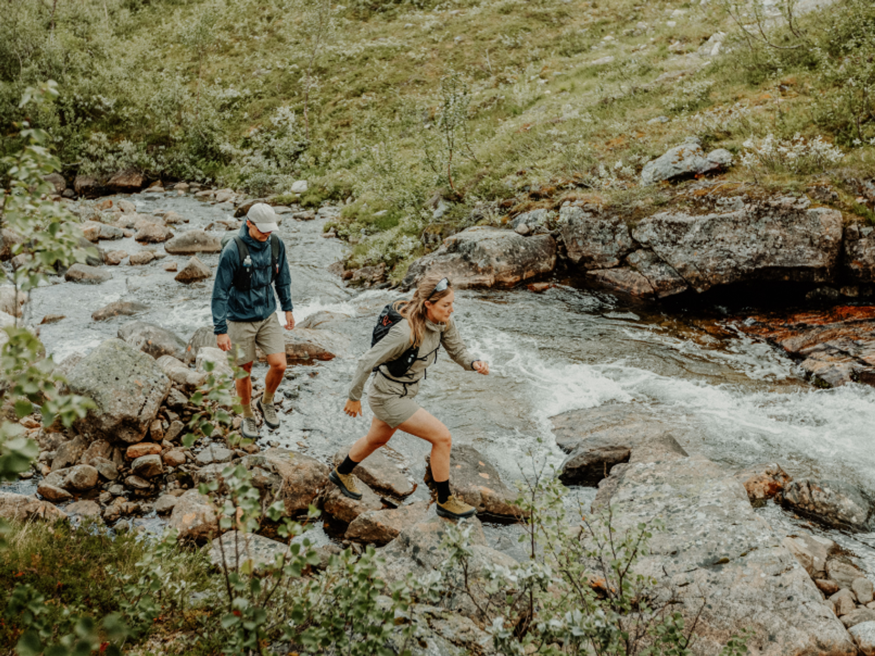 två fjällvandrare som går vid en fors