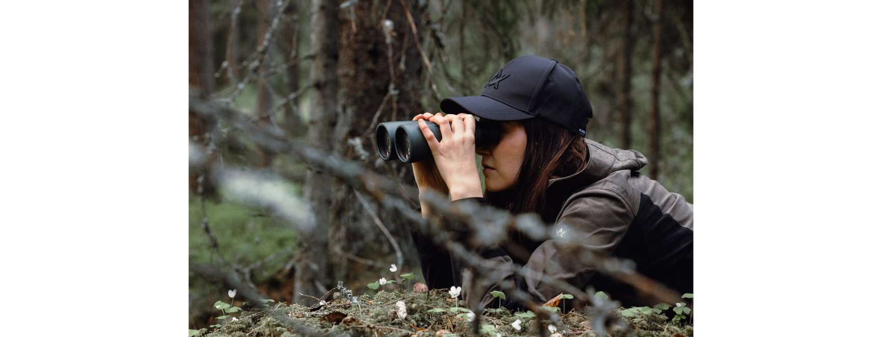 jägare i skogen som spanar i kikare