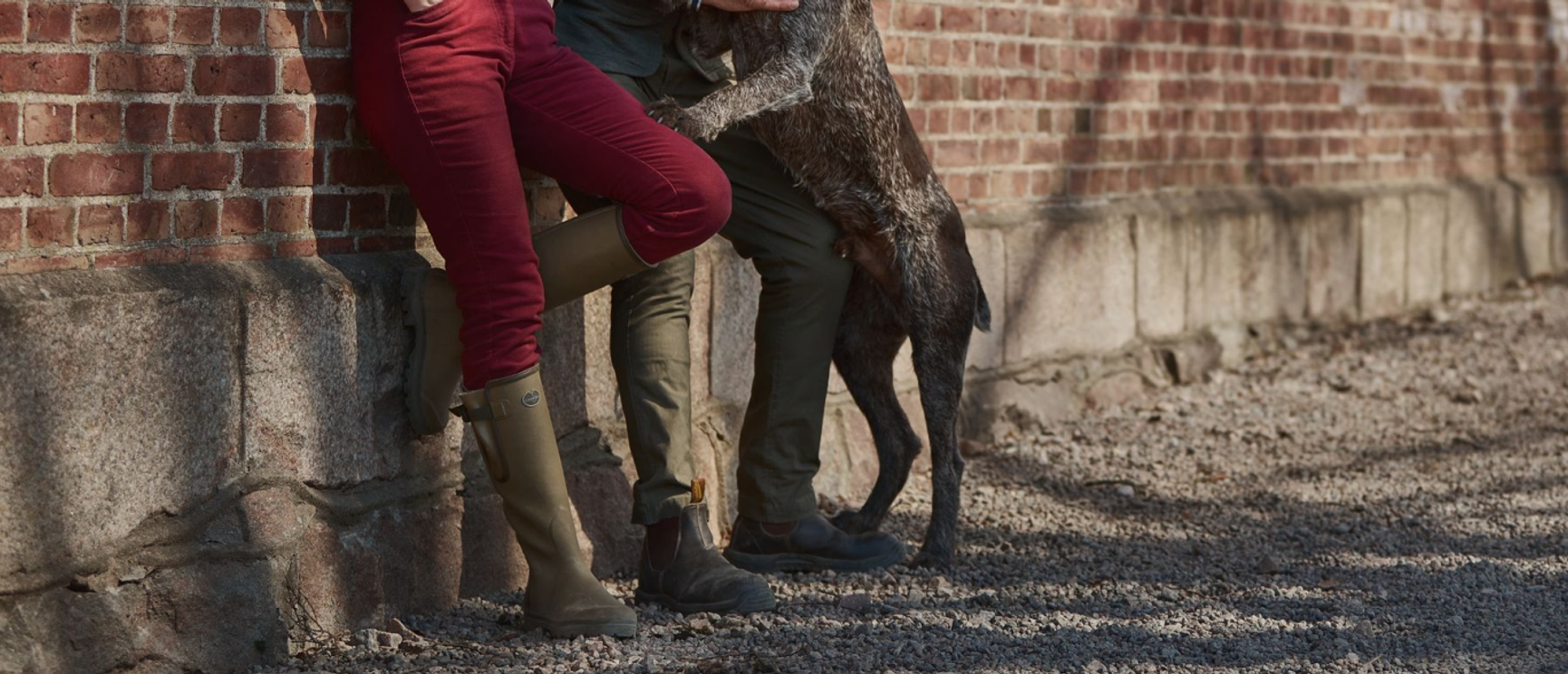 två personer som lutar sig mot en tegelvägg