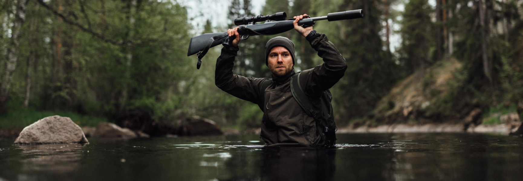 jägare som vadar över ett vattendrag