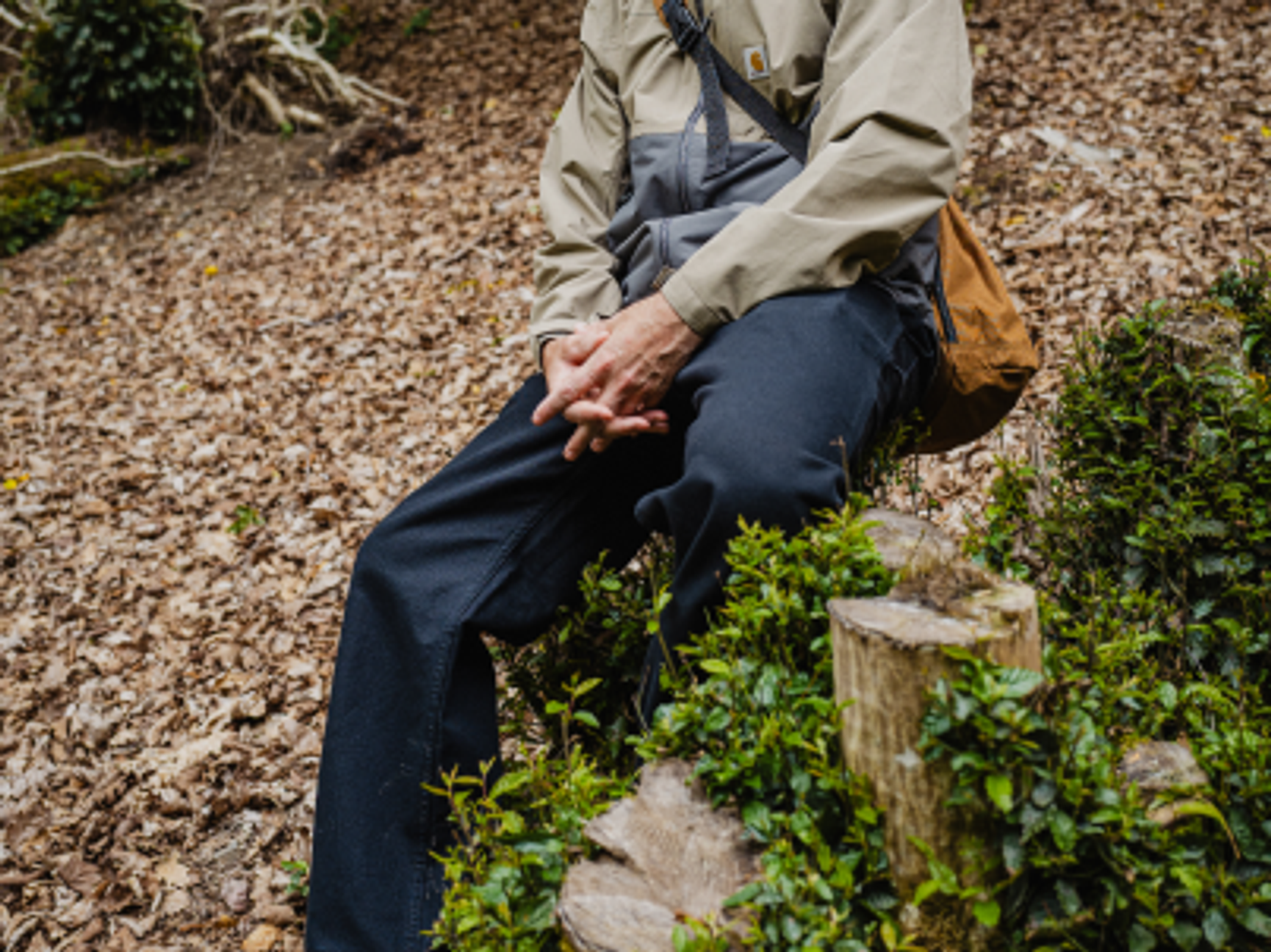 person som sitter på en stubbe
