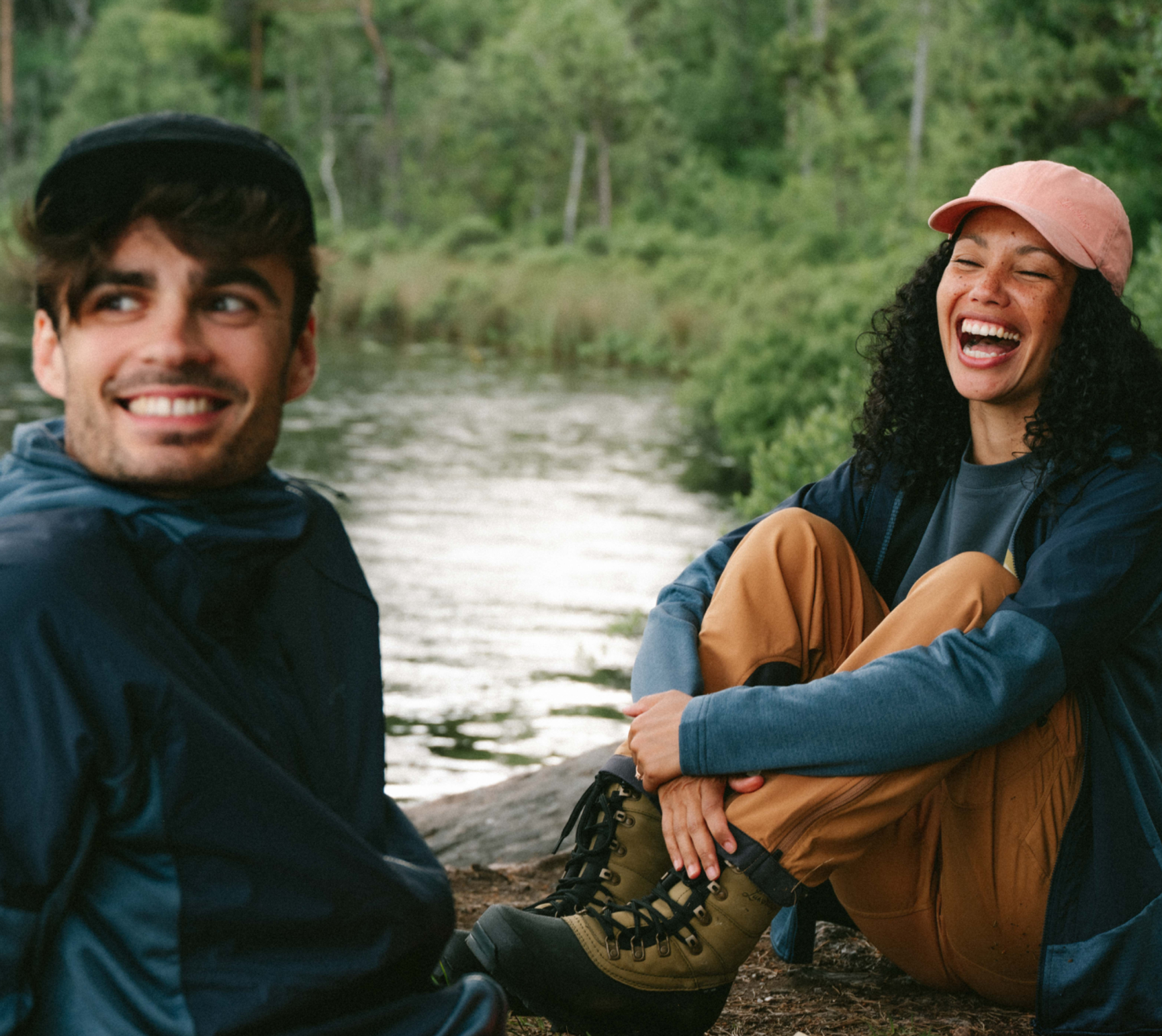 två personer i vandringskläder vid en å