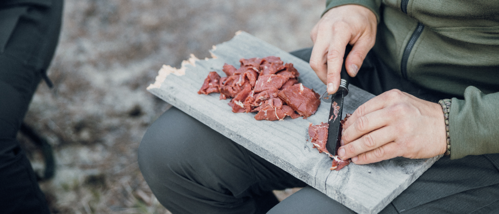 en kniv som skär tunna skivor kött på en skärbräda