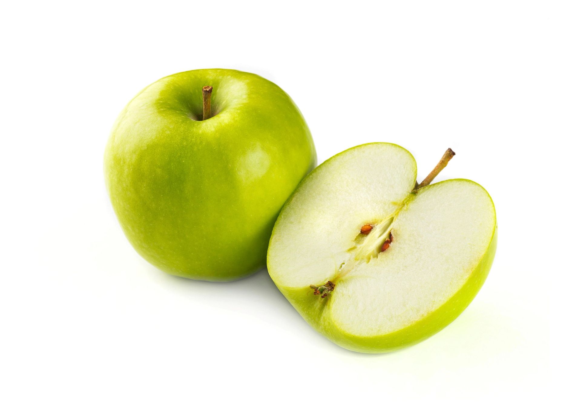 To grønne epler, hvorav ett er halvert og viser den lyse fruktkjernen.