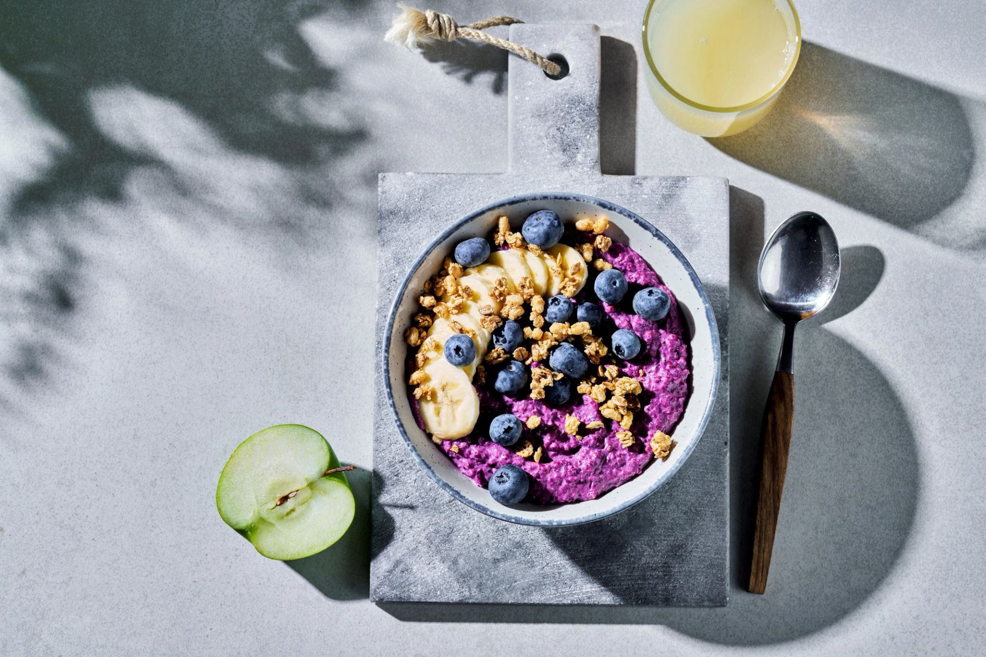 Skål med smoothiegrøt på en marmorfjøl, glass juice.