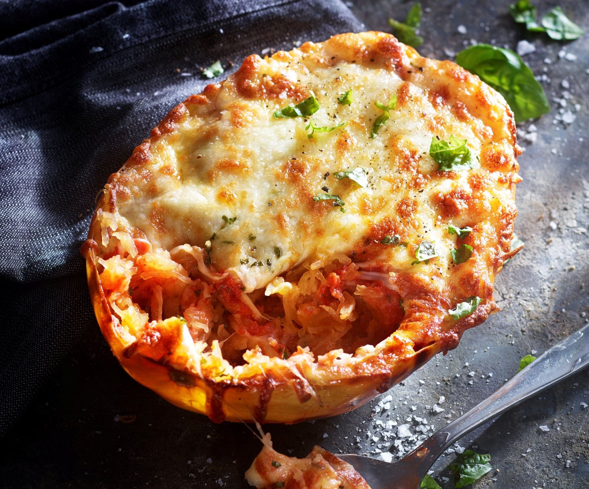 Gratinert spagettigresskar fylt med tomatsaus og smeltet ost, toppet med urter og servert rett fra formen.