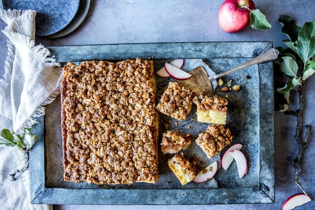 Eplekake med sprø nøttecrunch servert i firkanter på fat med ferske epleskiver