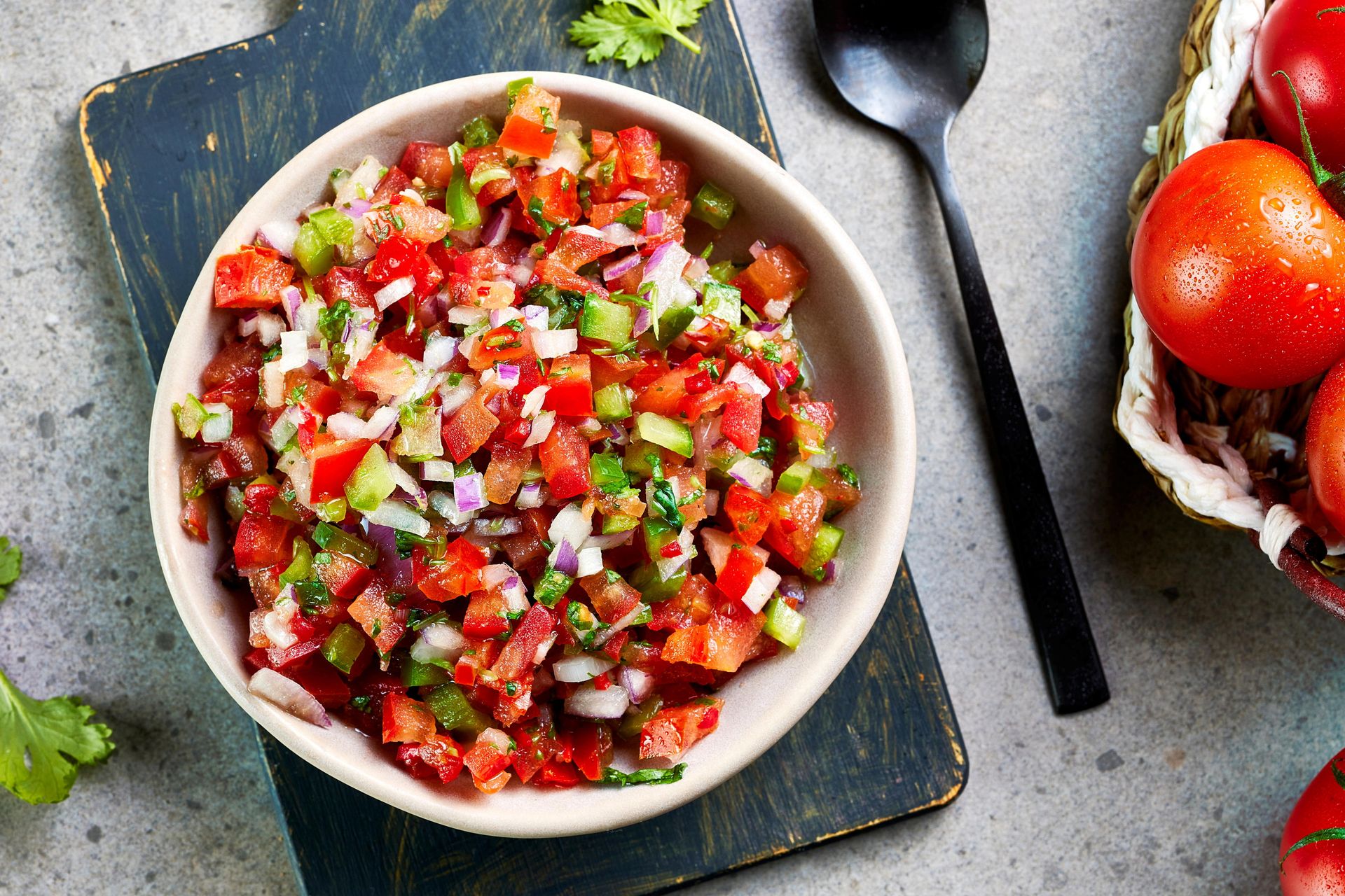Skål med pico de gallo laget av finhakkede tomater, rødløk, grønn chili og koriander.