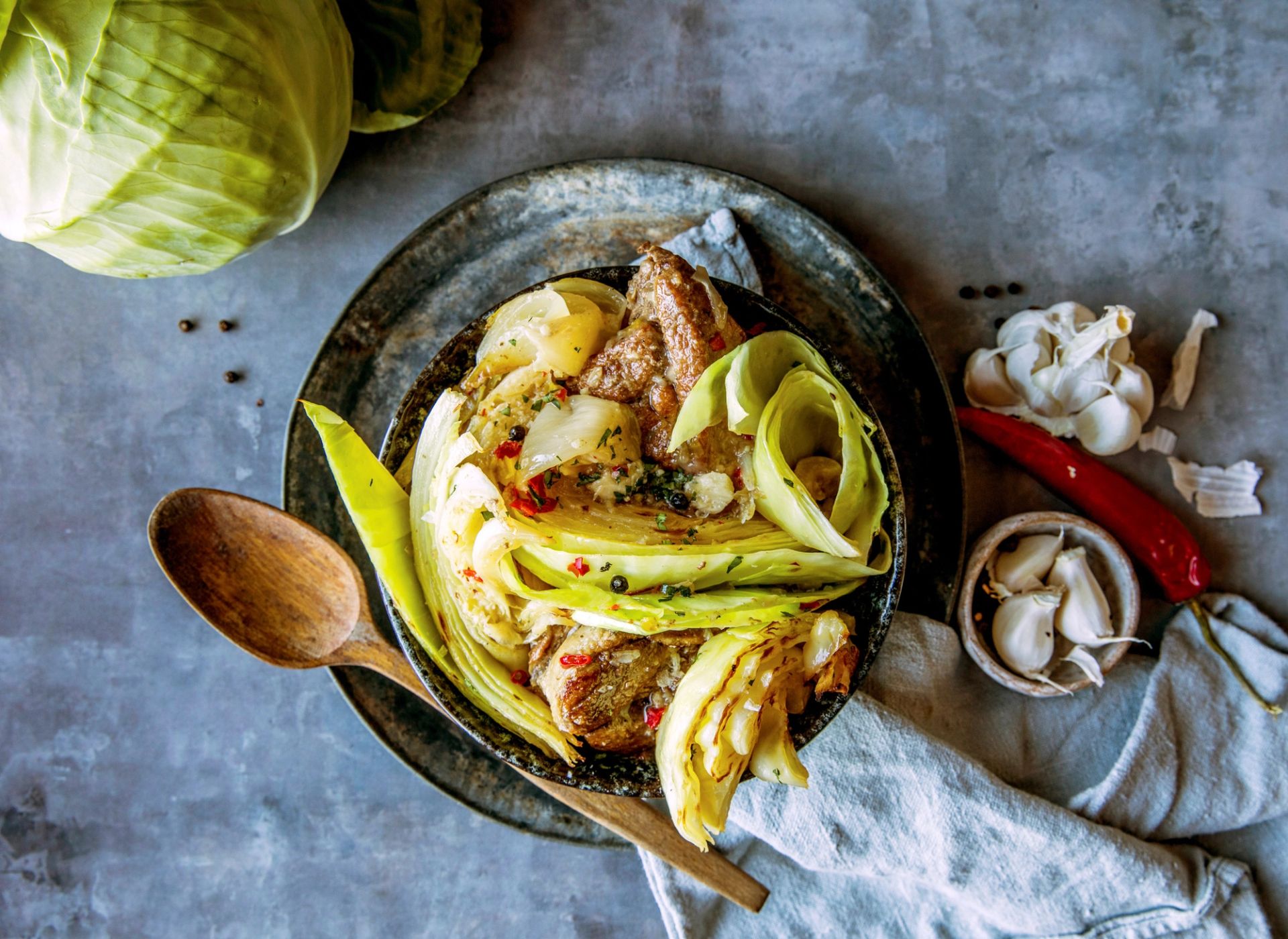 Brun fårikål med ingefær og chili servert i bolle med kål, hvitløk og krydder