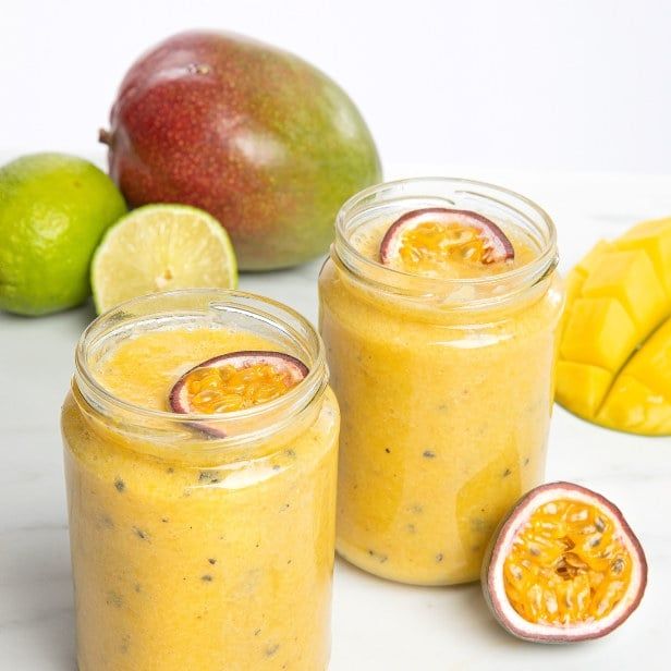 C‑vitaminrik smoothie med mango, pasjonsfrukt og sitrus, servert i glass med frisk frukt i bakgrunnen.