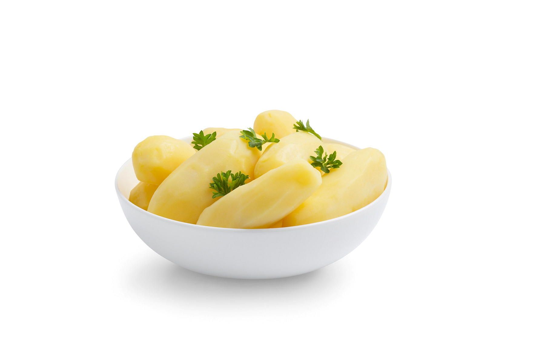 Skål med skrelte poteter pyntet med persille, plassert på hvit bakgrunn.