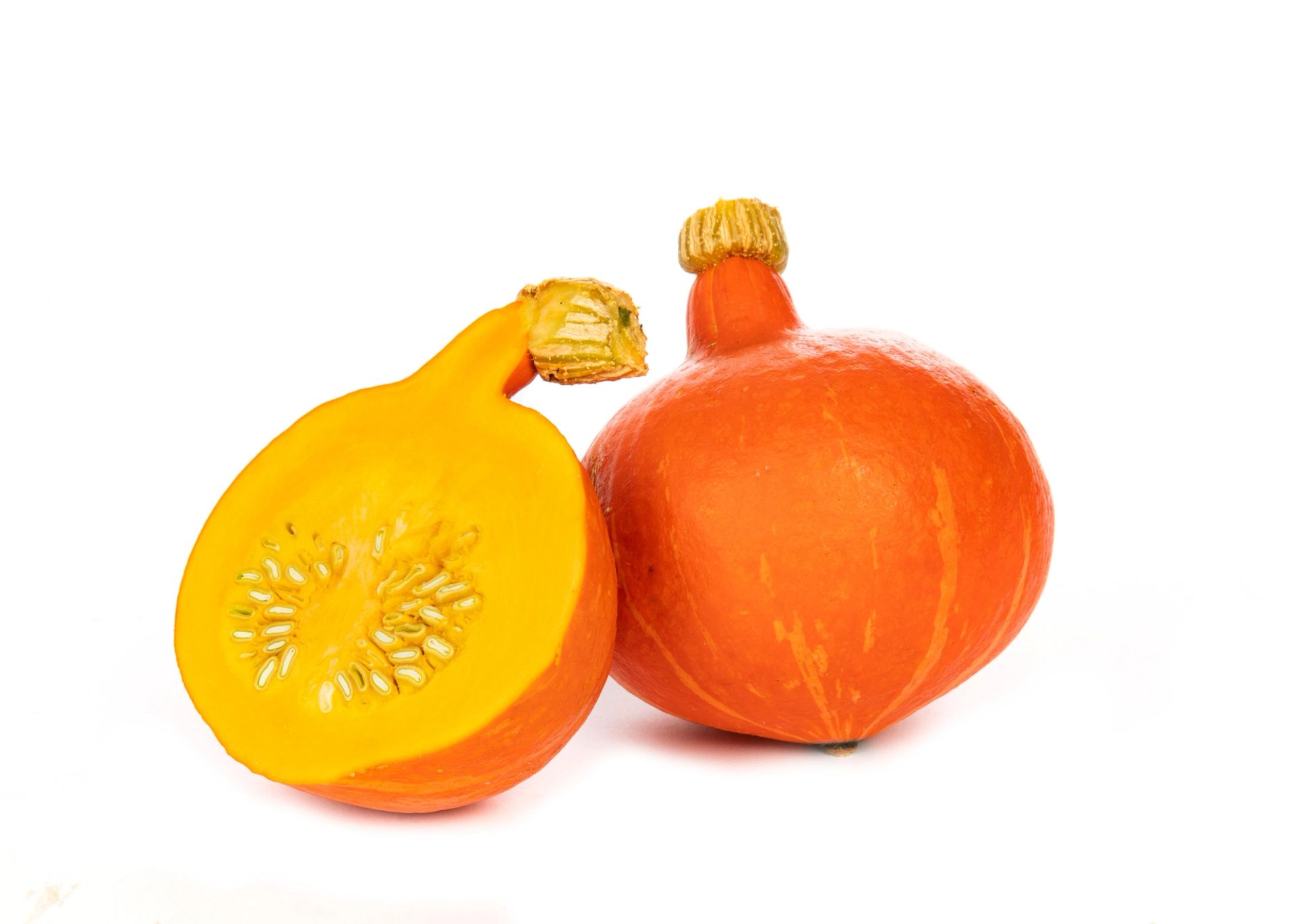 To oransje hokkaidogresskar på hvit bakgrunn, ett helt og ett delt i to. Det halve gresskaret viser det gule fruktkjøttet og kjernen med lyse frø.