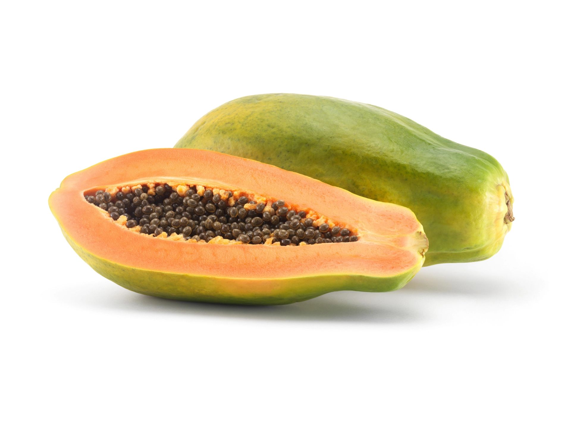 En hel papaya og en halvert papaya som viser det oransje fruktkjøttet og de mange små, svarte frøene inni, avbildet på en hvit bakgrunn.