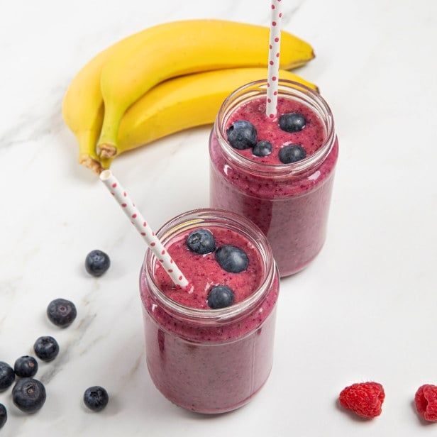 Fiberrik smoothie med banan, blåbær og bringebær, servert i glass og toppet med friske bær.