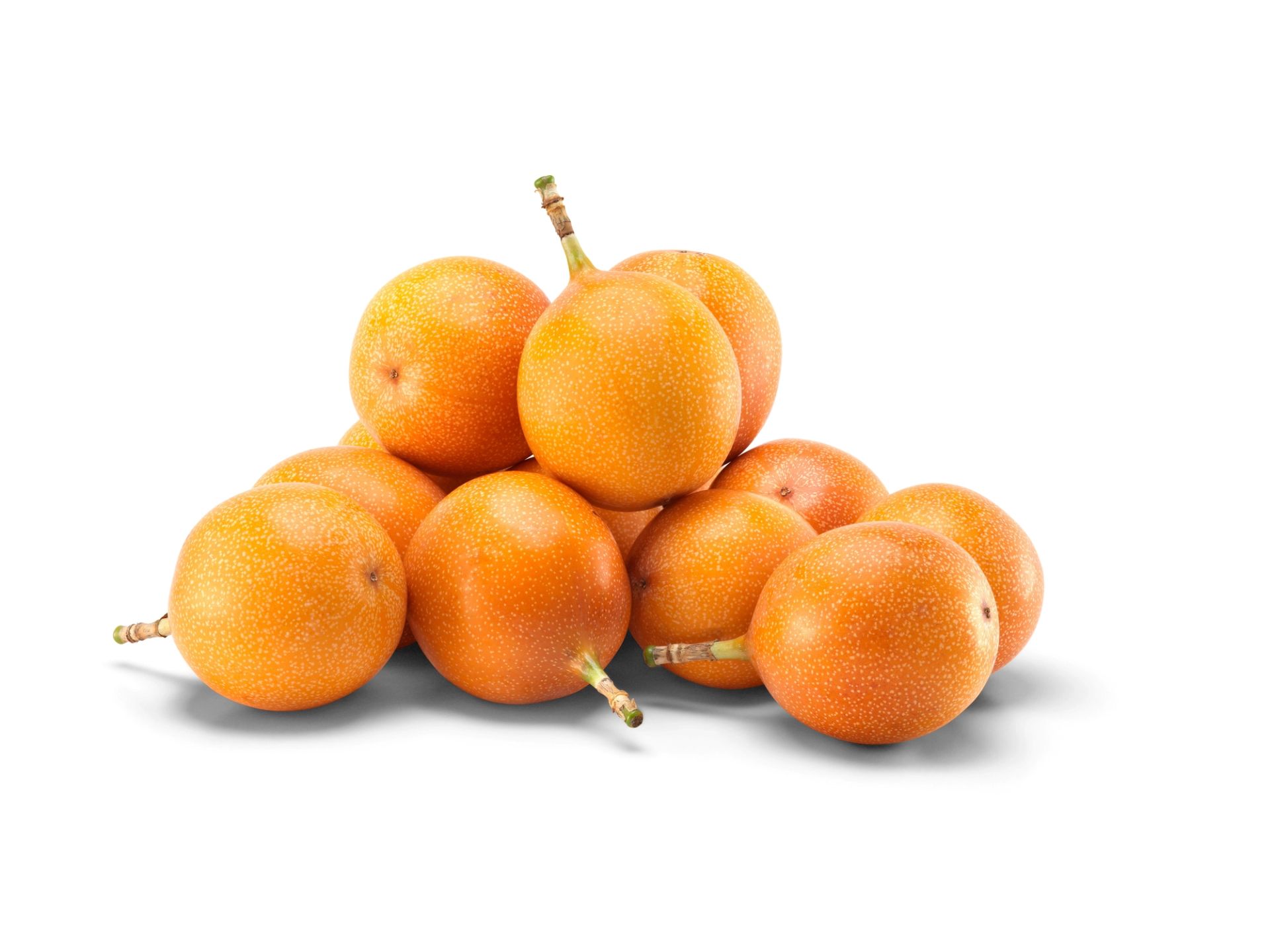 Flere hele granadilla-frukter stablet i en liten haug, med glatt oransje skall, fotografert mot hvit bakgrunn.