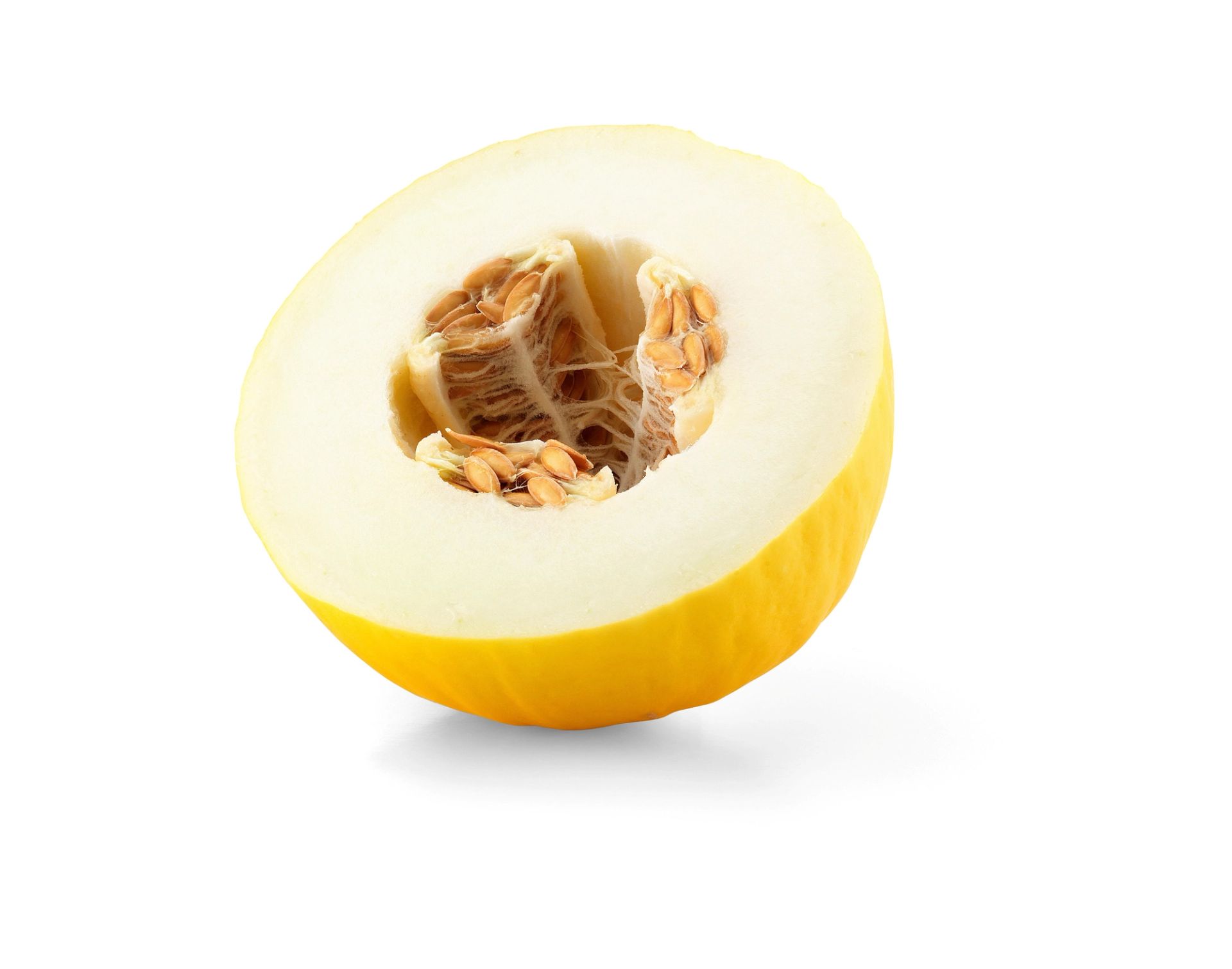 En halvert gul honningmelon med lys fruktkjøtt og synlige frø ligger med snittflaten vendt fremover.