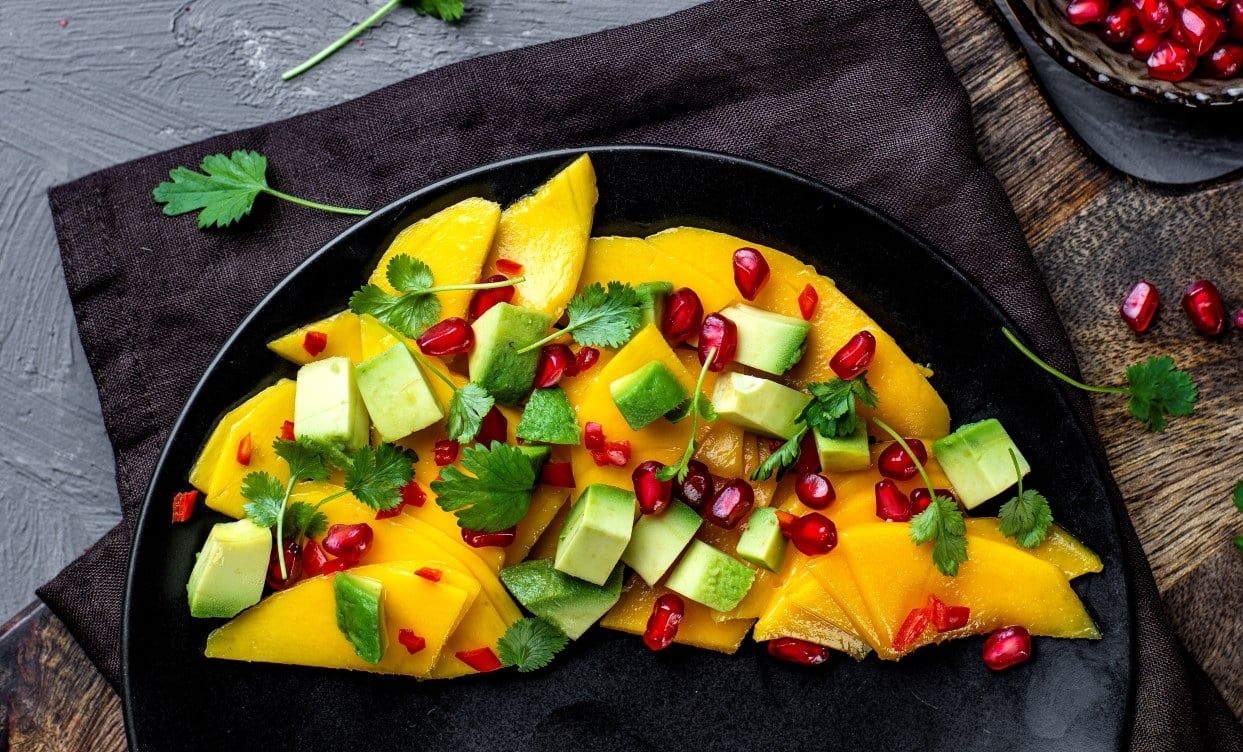 Mango‑ og avokadosalat med granateple og fersk koriander.