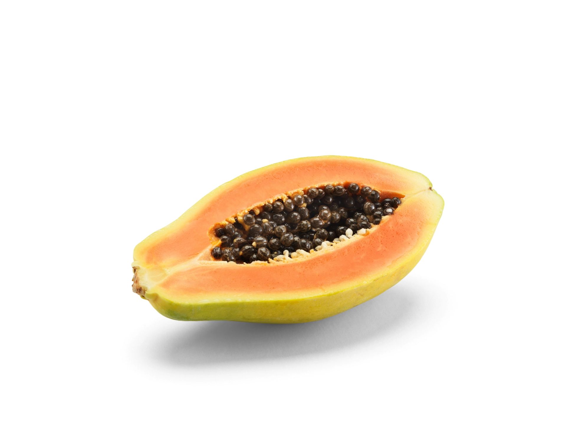 Halvert papaya med oransje fruktkjøtt og svarte kjerner i midten, plassert på en lys bakgrunn.