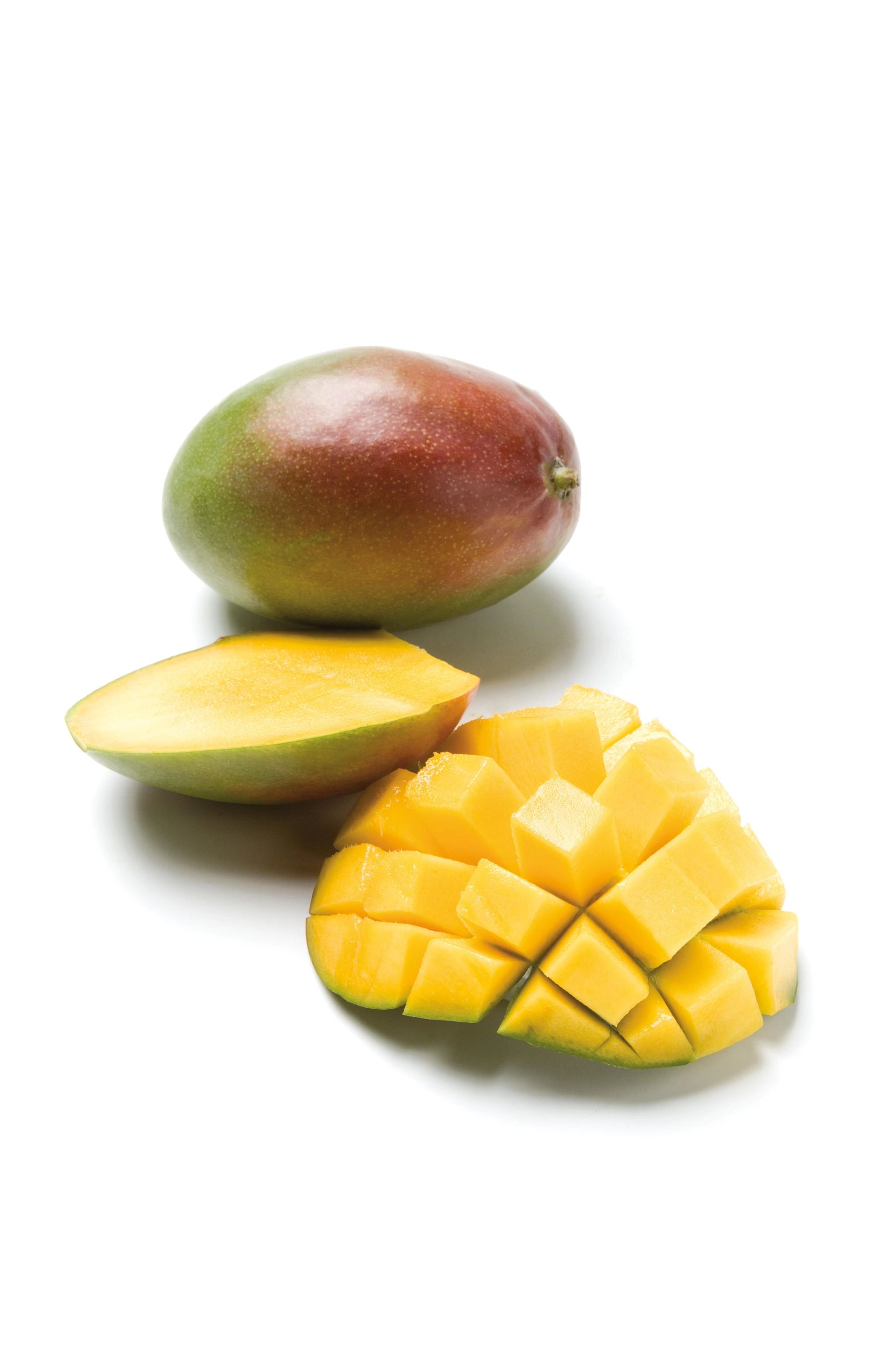 En hel mango og to mango­stykker foran den, inkludert et rutemønstret stykke med gult fruktkjøtt, plassert på hvit bakgrunn