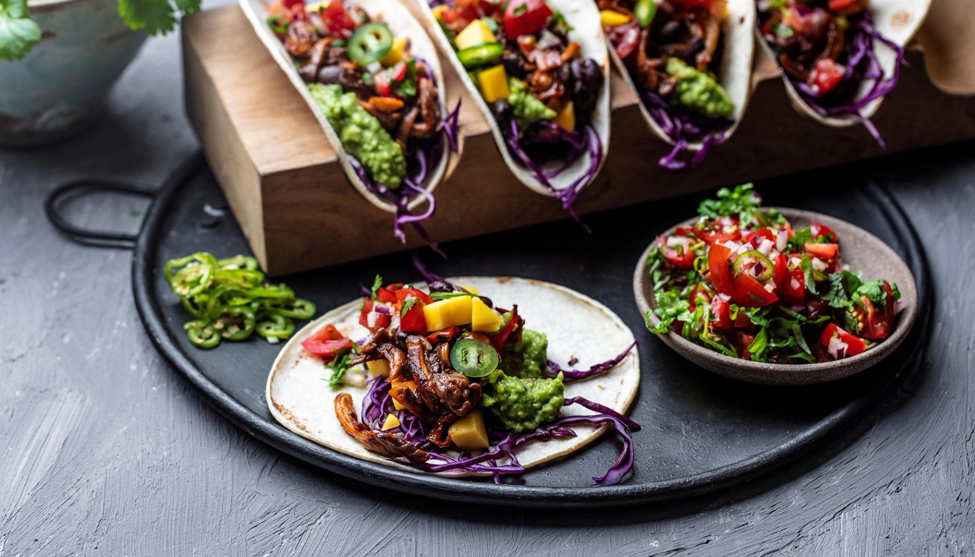 Taco med kremet soppstuing, frisk tomatsalsa og hjemmelaget guacamole, servert i tortillalefse med rødkål og mango.