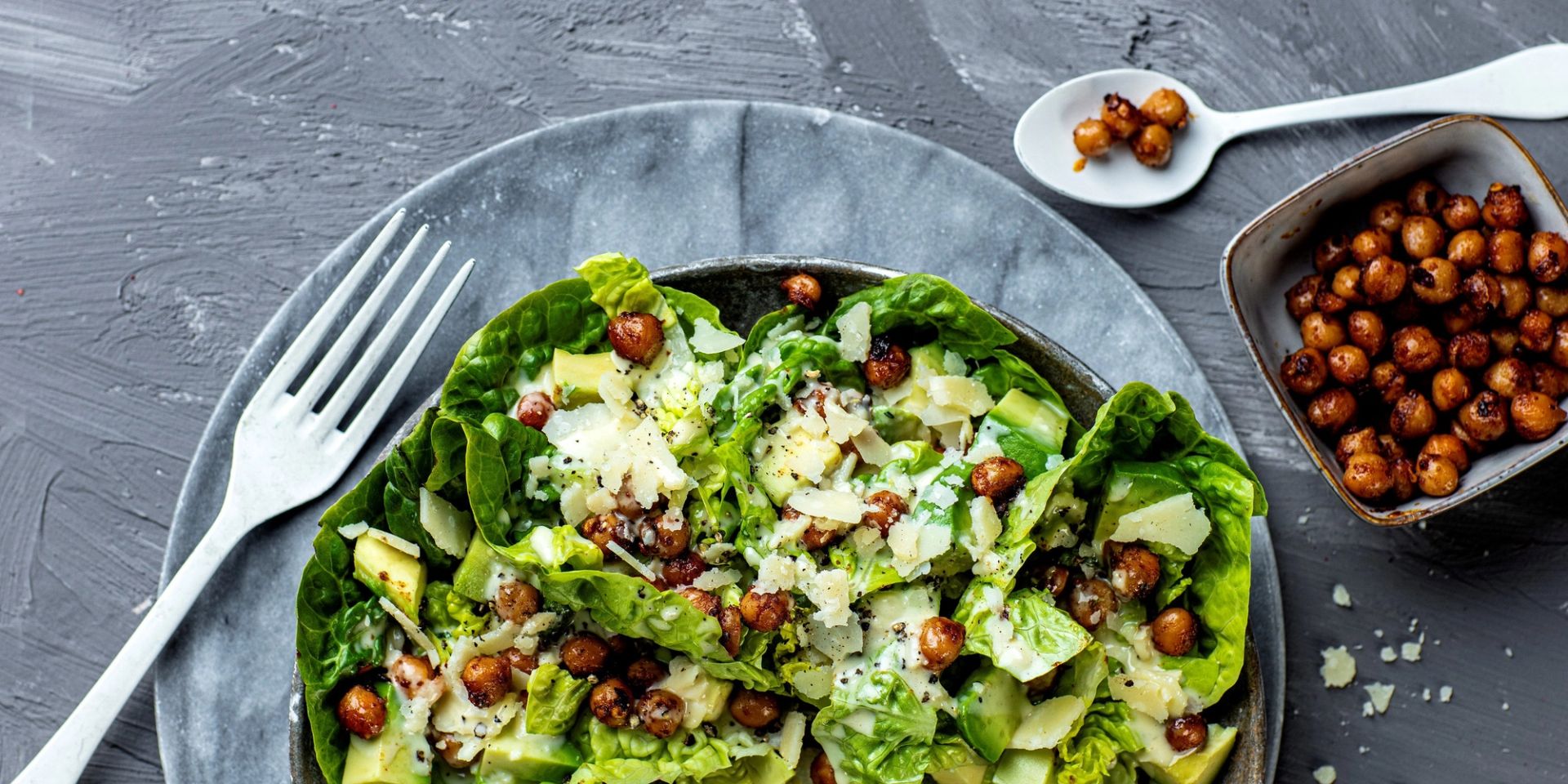 «Cæsar»-salat med hjertesalat, avokado, revet parmesan og sprø krydderstekte kikerter, servert med kremet dressing.