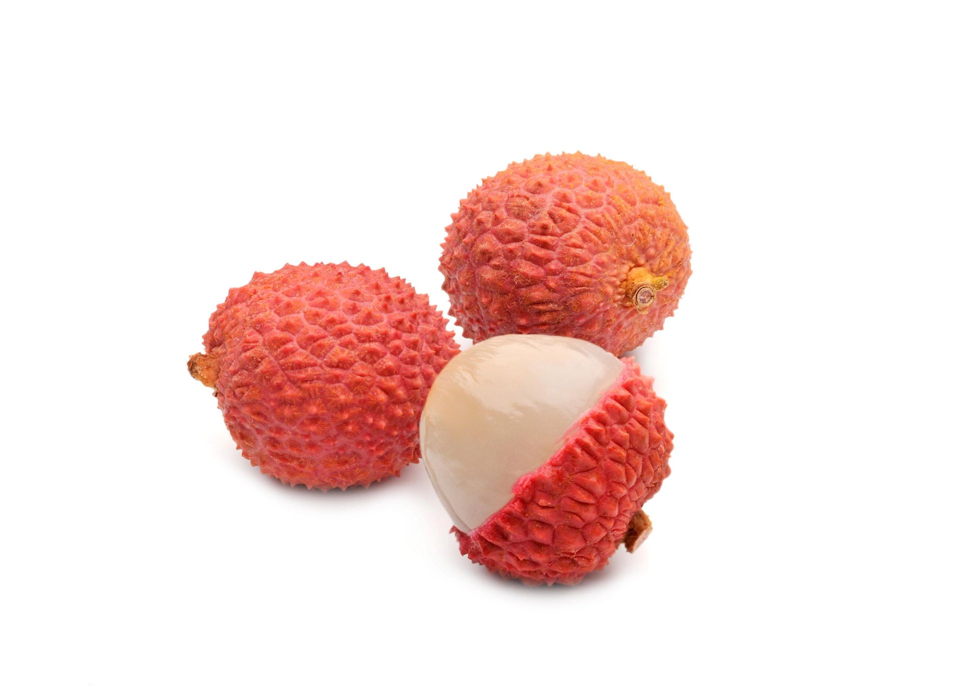 Tre lychee-frukter med rødt, knudrete skall, der én er delvis skrellet og viser det hvite, glinsende fruktkjøttet