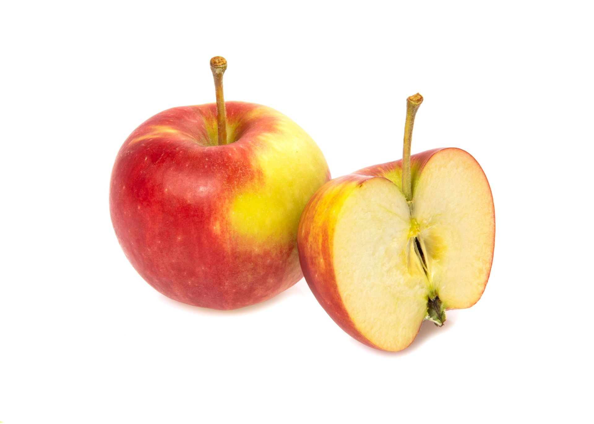 Et rødt og gult eple står ved siden av et halvert eple som viser den lyse fruktkjernen og stilken.