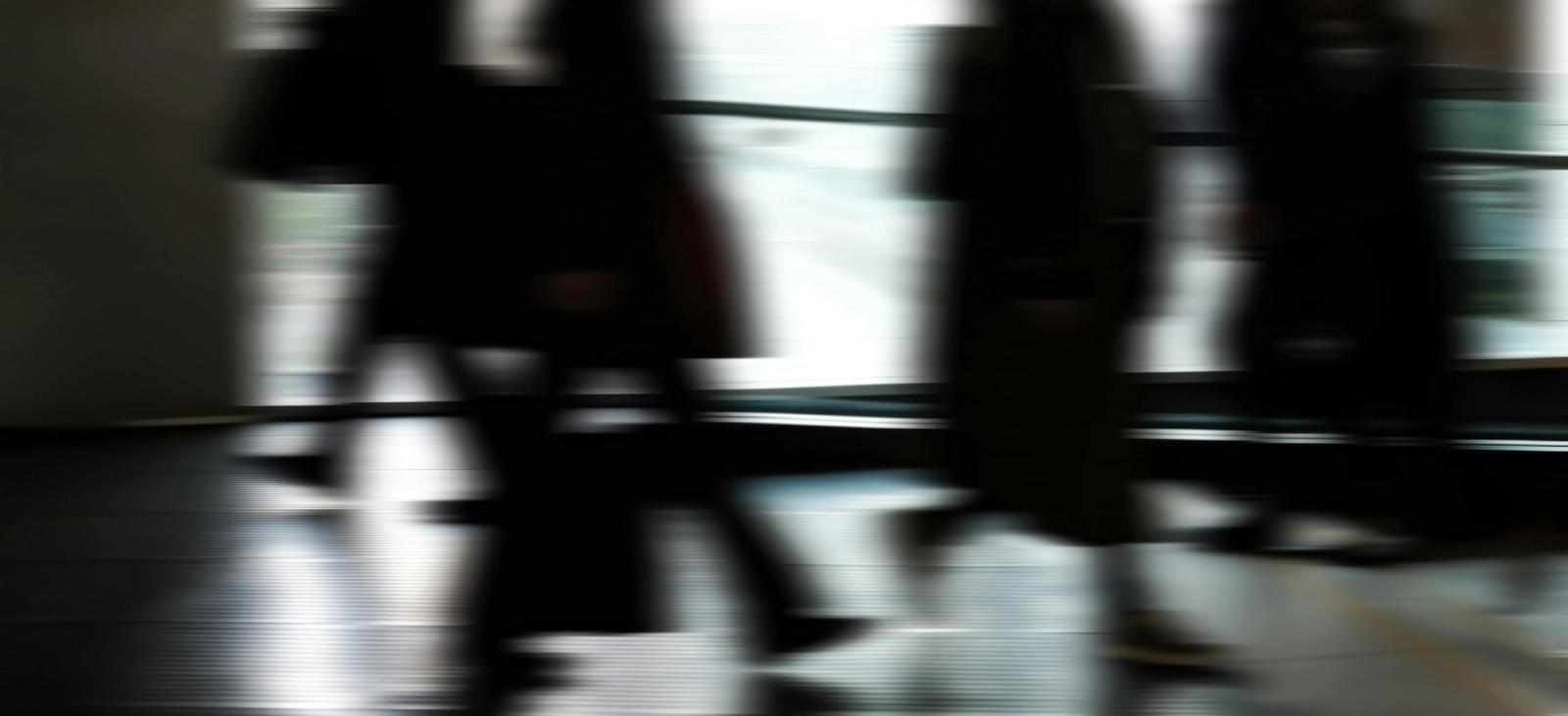A motion blurred streetscape with a group of office commuters.