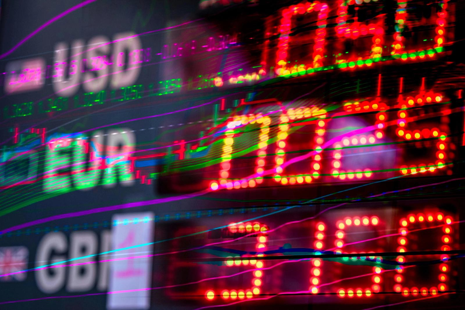A neon screen reporting foreign exchange rates.