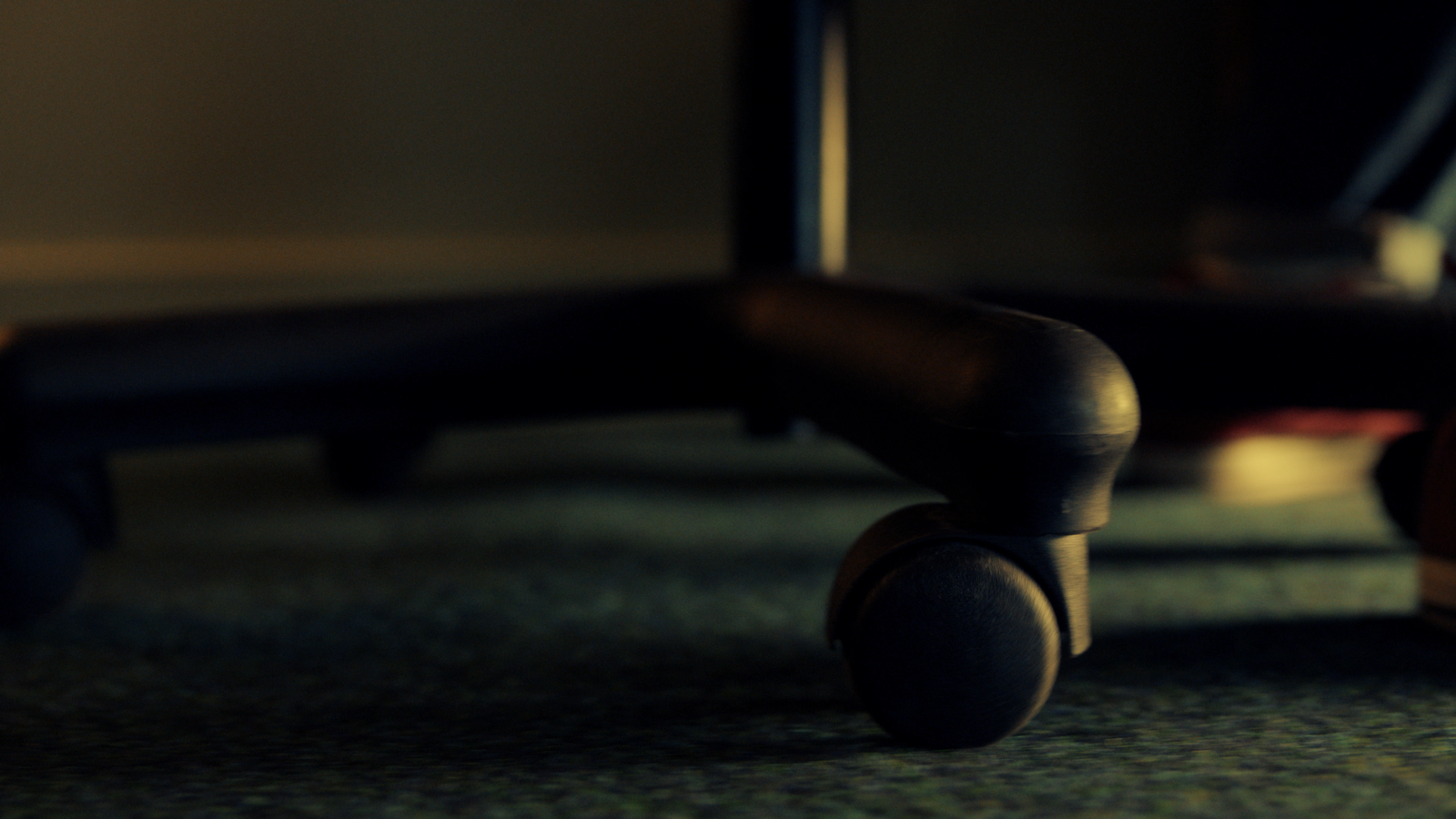 The base of an office chair with rolling caster wheels.