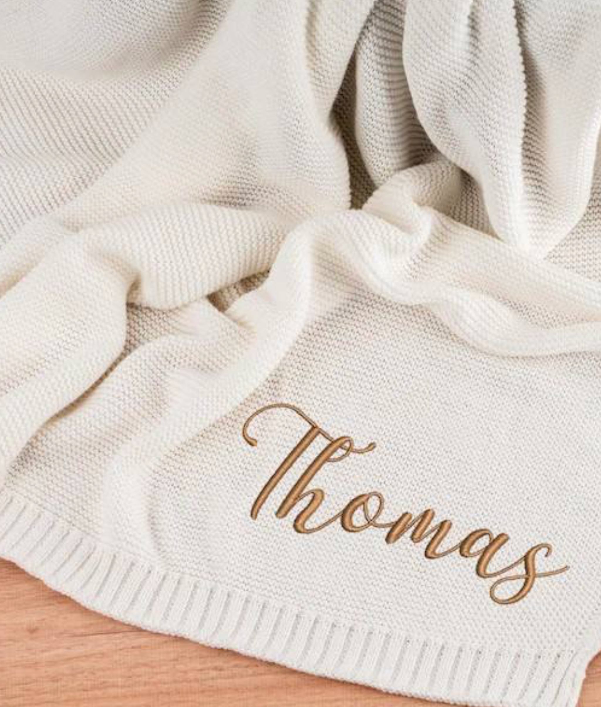 Cream cable-knit baby blanket with a teddy bear