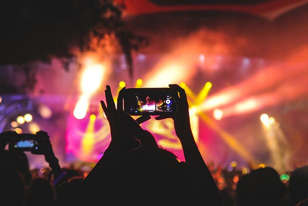 Image of a person taking a picture in a concert