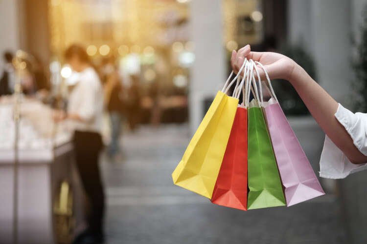 Young woman holding shopping bags symbolizing retail challenges and customer behavior - Global Banking & Finance Review