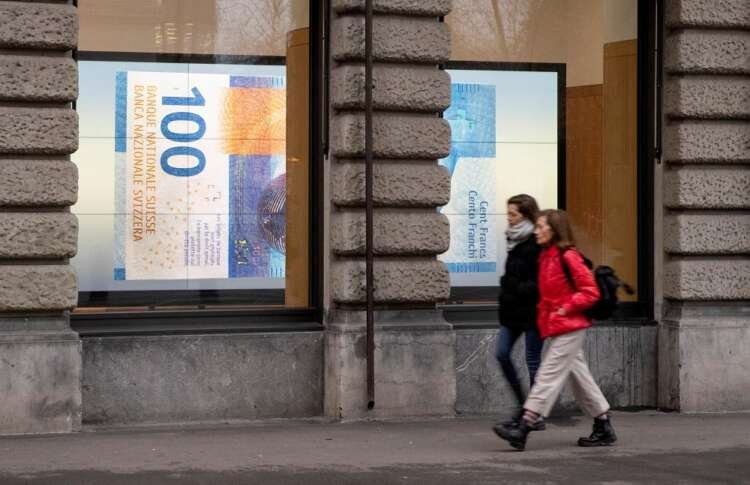 Projection of a 100 franc banknote in Zurich representing Swiss franc's safe haven status - Global Banking & Finance Review