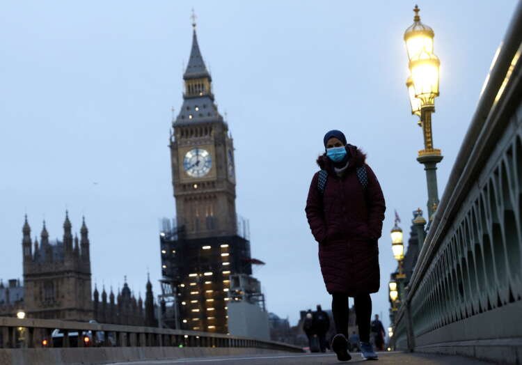 Person in a protective mask crossing Westminster Bridge during COVID-19 pandemic - Global Banking & Finance Review